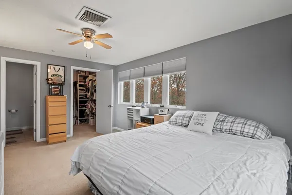 a bedroom with a large bed and a chandelier