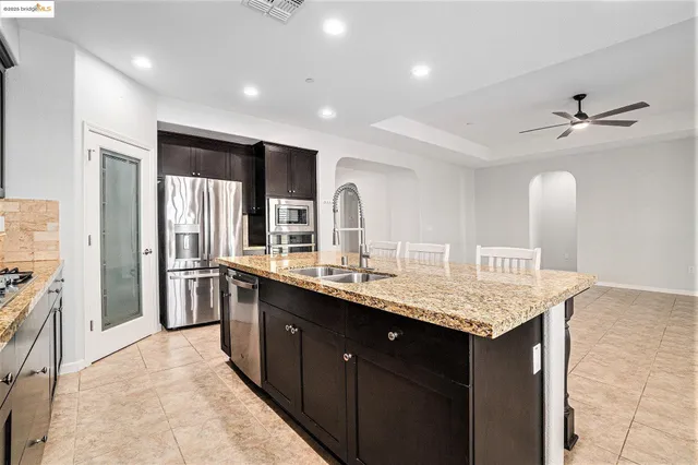 a kitchen with kitchen island granite countertop wooden cabinets a dining table and chairs