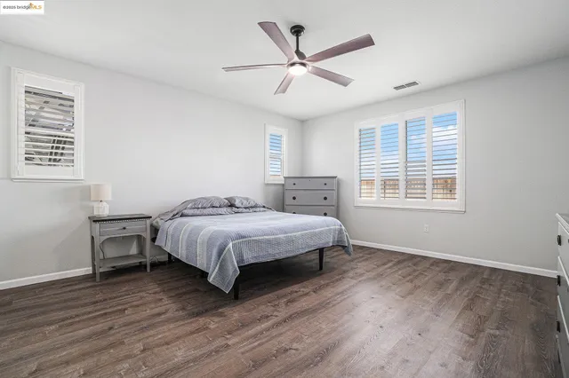 a bedroom with a flat screen tv on dresser and a flat screen tv