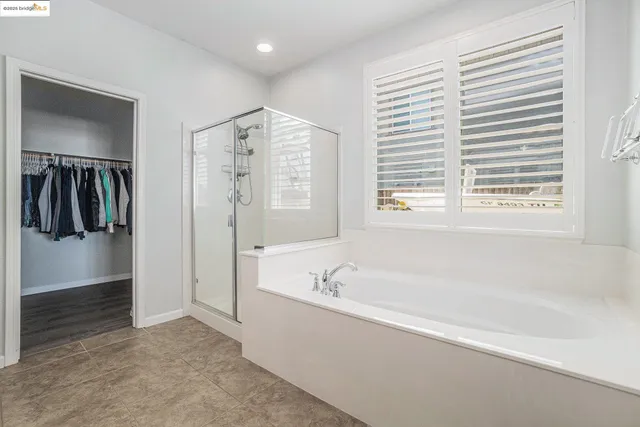 a spacious bathroom with a tub sink and mirror