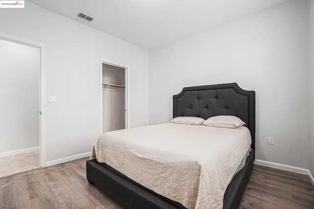 a large bed sitting in a bedroom next to a window