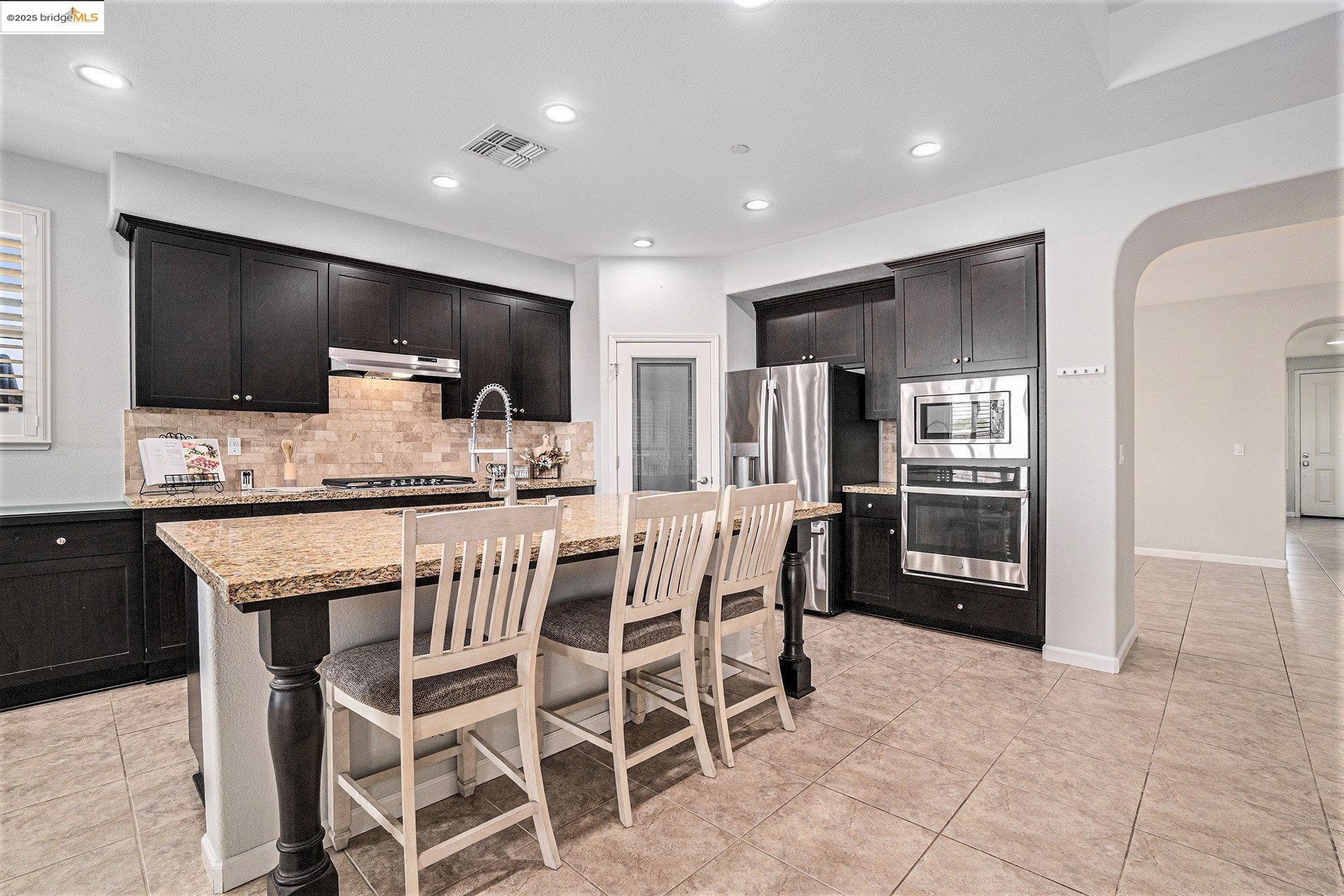31 Rustic Court Oakley, CA 94561 - Photo 9 of 52 a kitchen with stainless steel appliances a dining table chairs and refrigerator