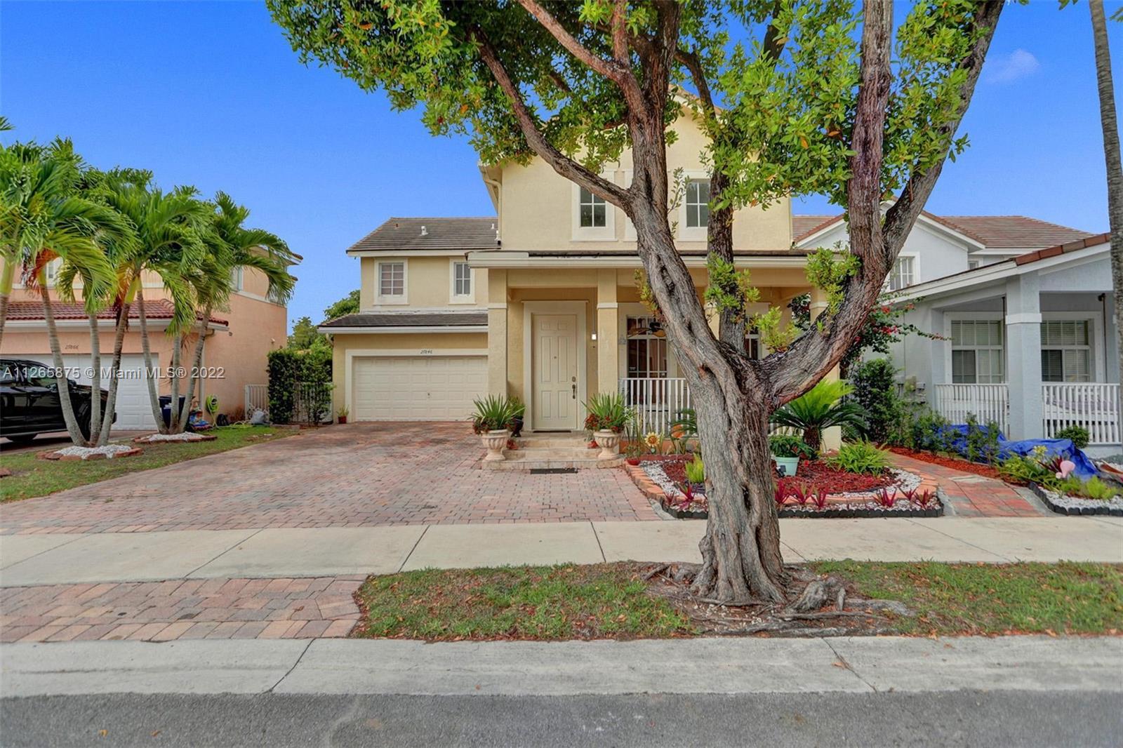 a front view of a house with garden and parking