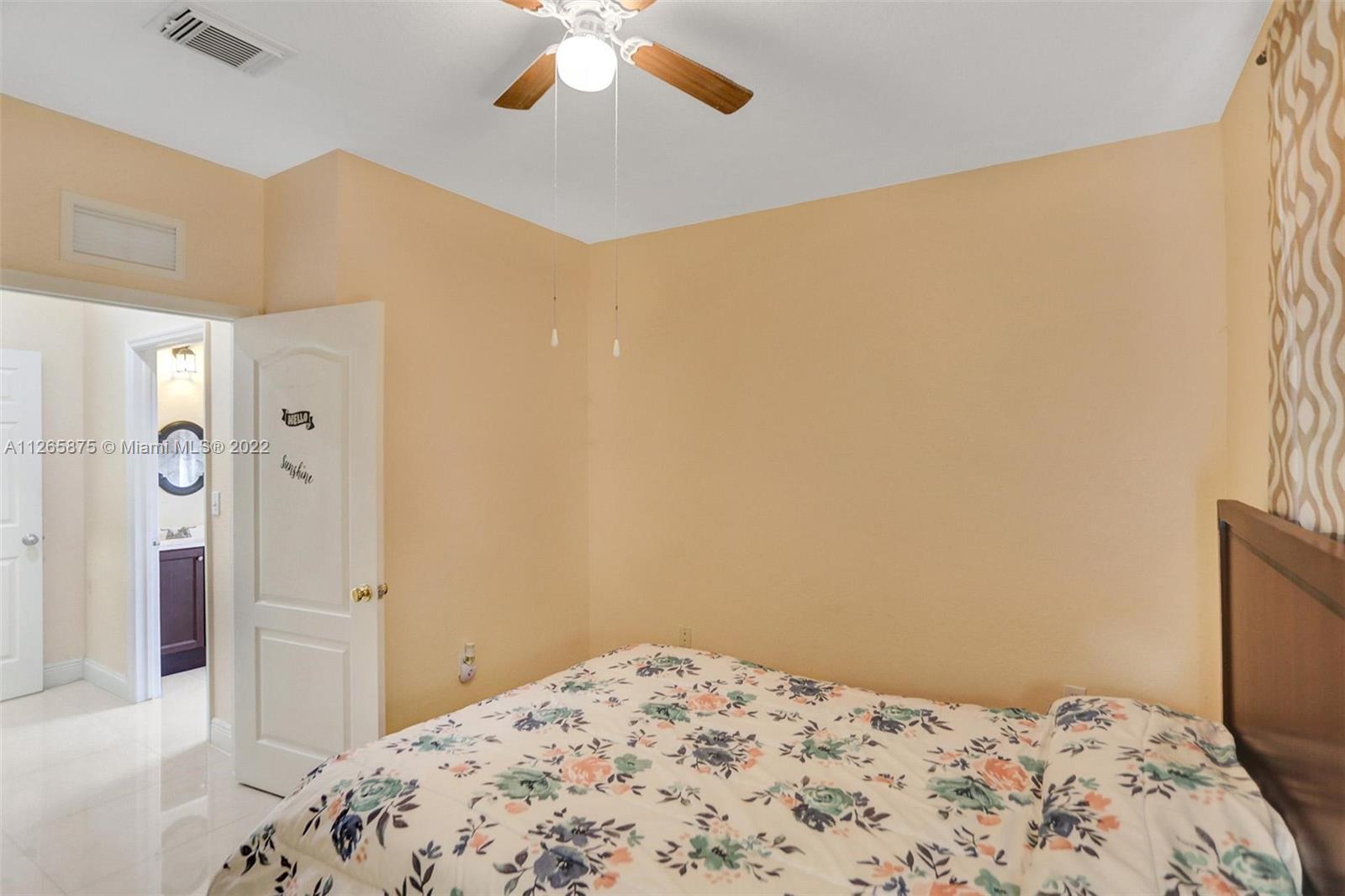 27846 Southwest 142nd Avenue Homestead, FL 33032 - Photo 21 of 56 a bedroom with a bed and a chandelier