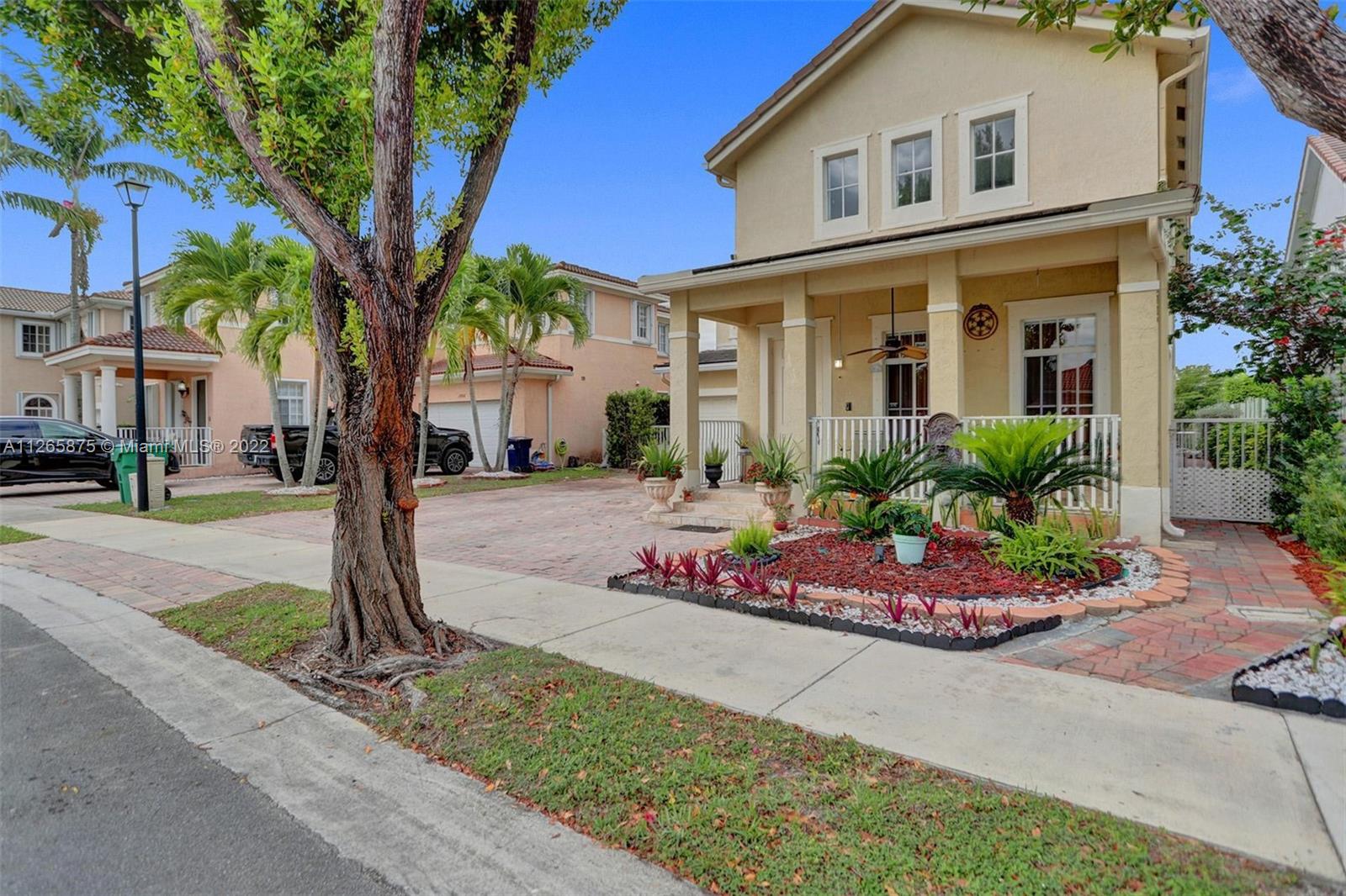 27846 Southwest 142nd Avenue Homestead, FL 33032 - Photo 3 of 56 a front view of a house with a yard and potted plants