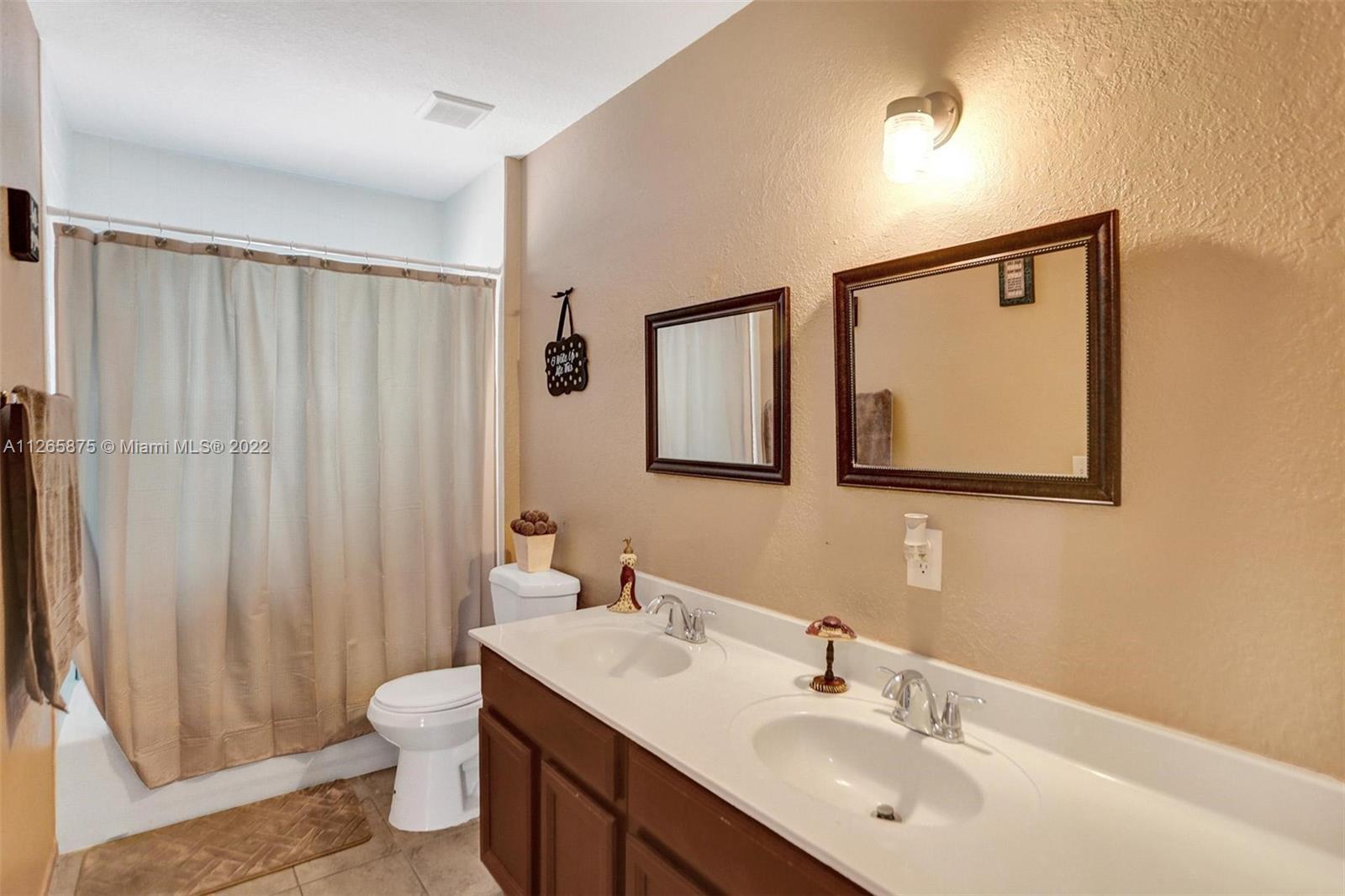 27846 Southwest 142nd Avenue Homestead, FL 33032 - Photo 35 of 56 a bathroom with a sink mirror and a toilet