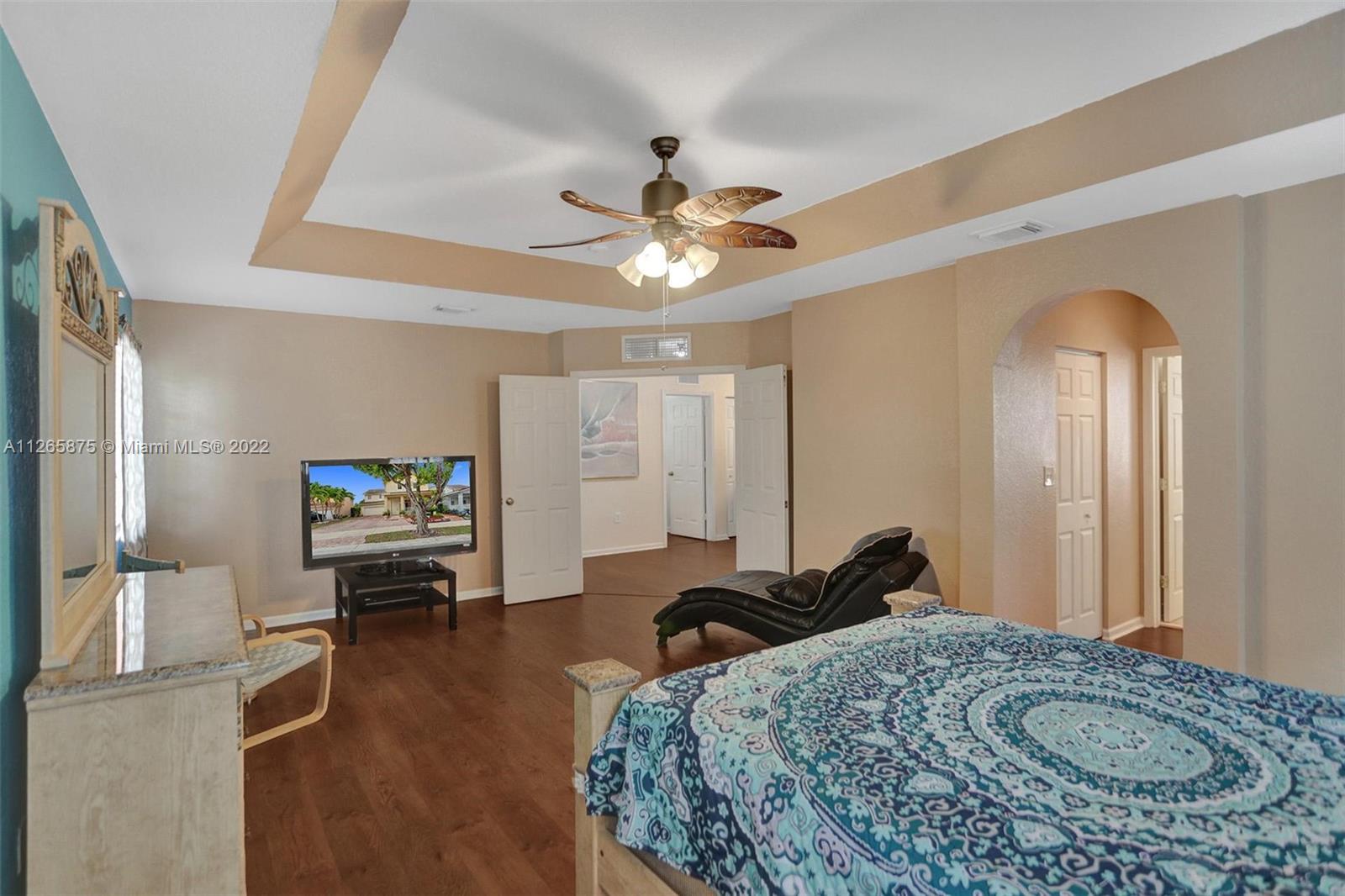27846 Southwest 142nd Avenue Homestead, FL 33032 - Photo 39 of 56 a bedroom with a bed and a chandelier