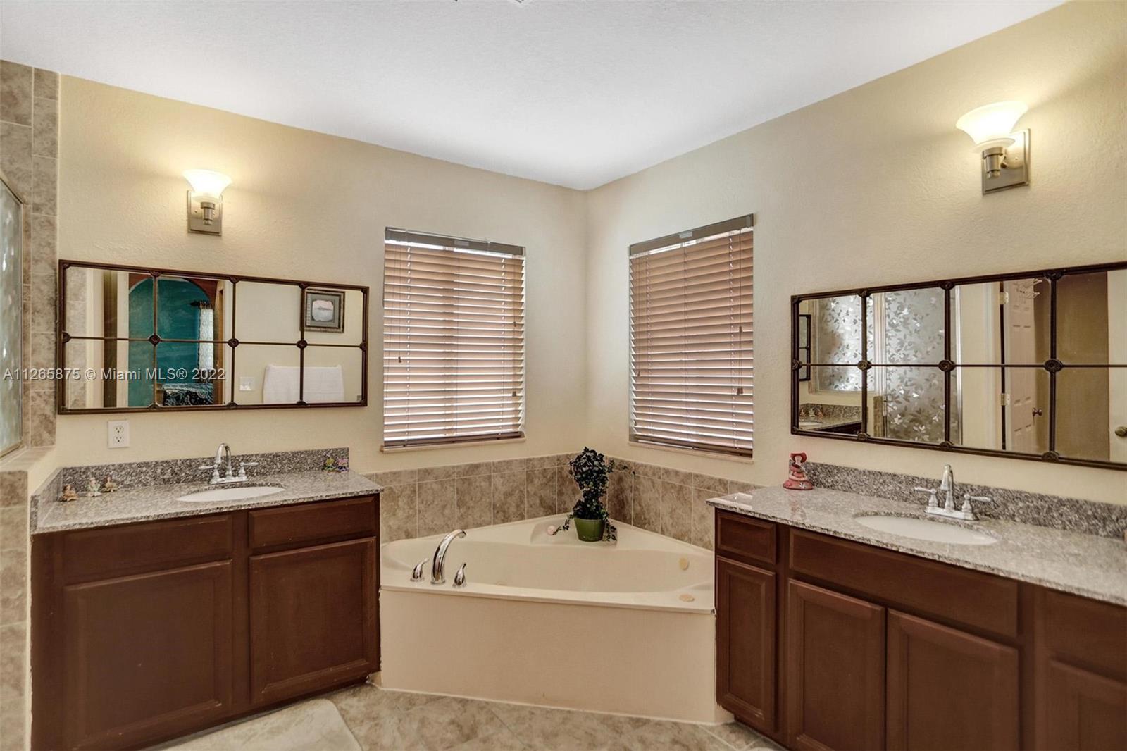 27846 Southwest 142nd Avenue Homestead, FL 33032 - Photo 41 of 56 a bathroom with a granite countertop bathtub a sink and a window