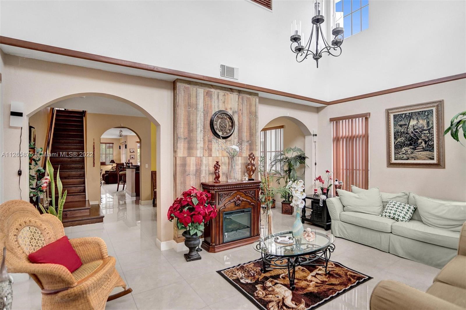 27846 Southwest 142nd Avenue Homestead, FL 33032 - Photo 5 of 56 a living room with furniture and a chandelier