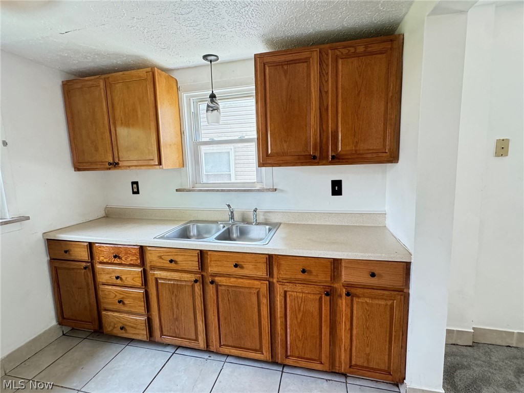 459 Patterson Avenue Akron, OH 44310 - Photo 19 of 24 1st floor apt. Kitchen featuring decorative light fixtures, sink, a textured ceiling, and light tile floors