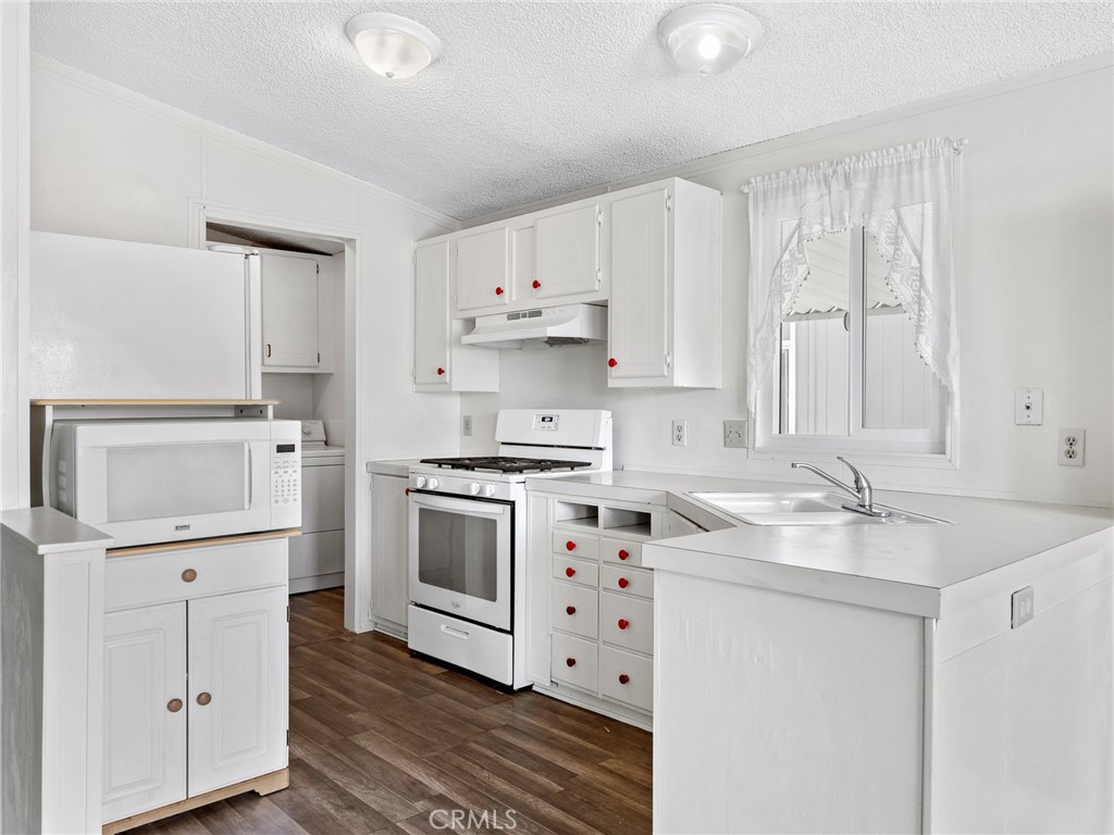 22020 Nisqually Road, Unit 3 Apple Valley, CA 92308 - Photo 12 of 35 a kitchen with a stove a sink and a refrigerator