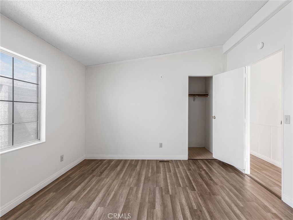 22020 Nisqually Road, Unit 3 Apple Valley, CA 92308 - Photo 17 of 35 an empty room with wooden floor and windows