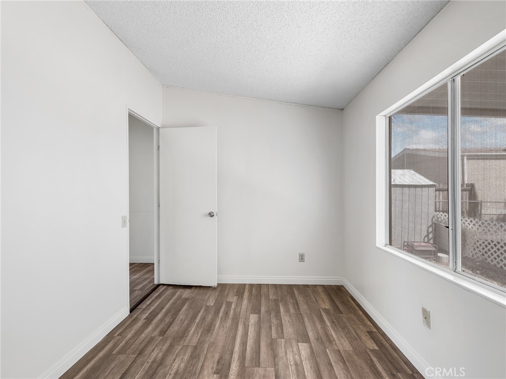 22020 Nisqually Road, Unit 3 Apple Valley, CA 92308 - Photo 19 of 35 a view of an empty room with wooden floor and a window