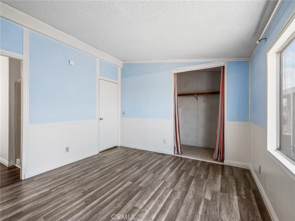 22020 Nisqually Road, Unit 3 Apple Valley, CA 92308 - Photo 23 of 35 a view of an empty room with wooden floor and a window