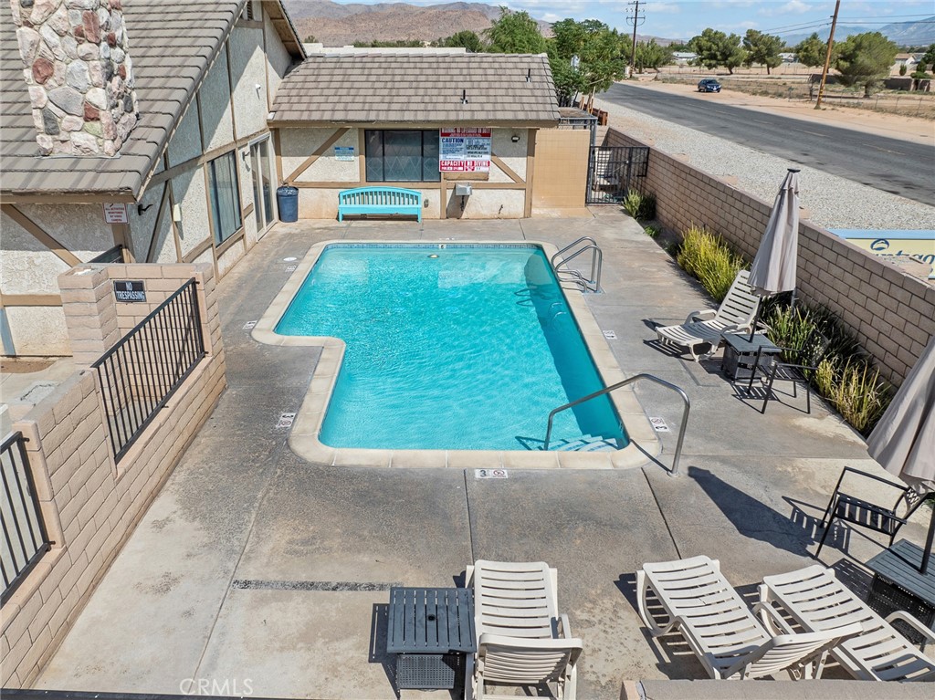 22020 Nisqually Road, Unit 3 Apple Valley, CA 92308 - Photo 33 of 35 a view of a patio with couches table and chairs with wooden floor
