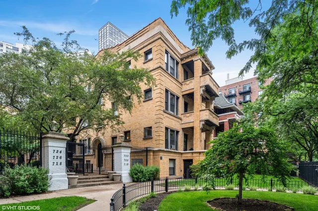 a view of a white house with a big yard and large trees