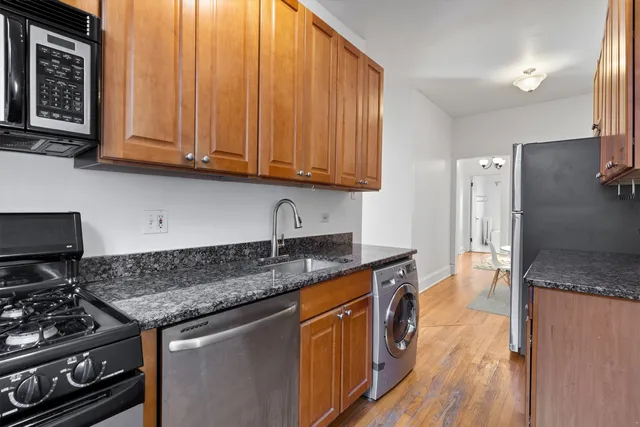 a kitchen with stainless steel appliances granite countertop a stove a sink and a microwave