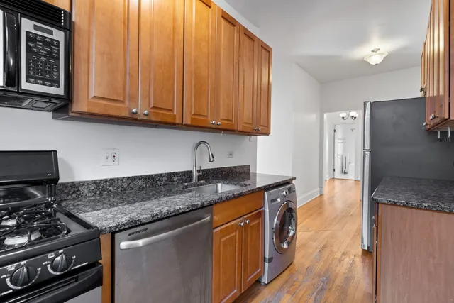a kitchen with stainless steel appliances granite countertop a stove a sink and a microwave