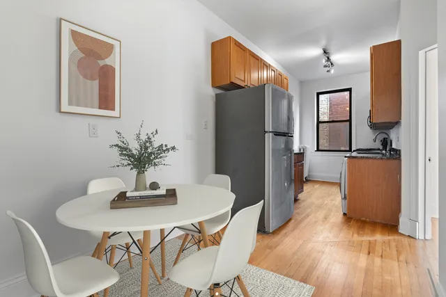 a kitchen with sink refrigerator dining table and chairs