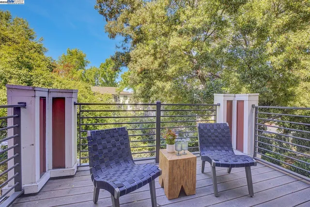 a balcony with wooden floor and outdoor seating