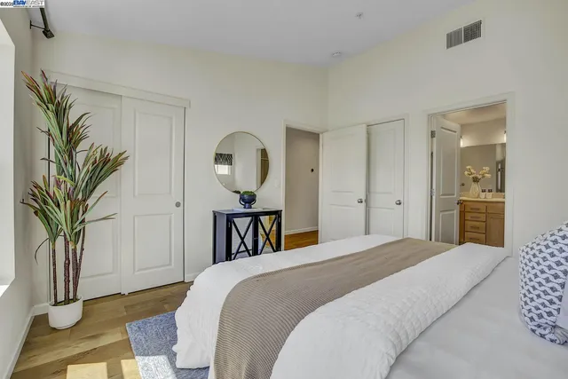 a bedroom with a bed and a potted plant