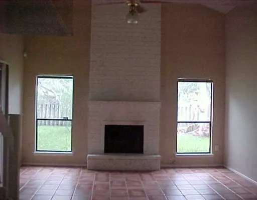 a view of a livingroom with a fireplace and window