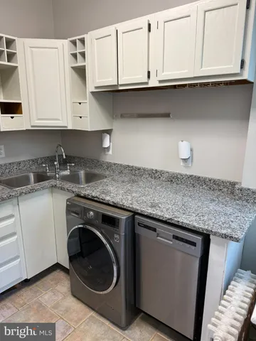 a kitchen with granite countertop white cabinets and a sink