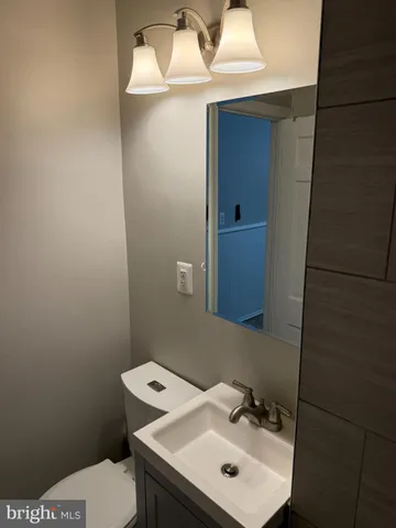 a bathroom with a sink toilet and mirror