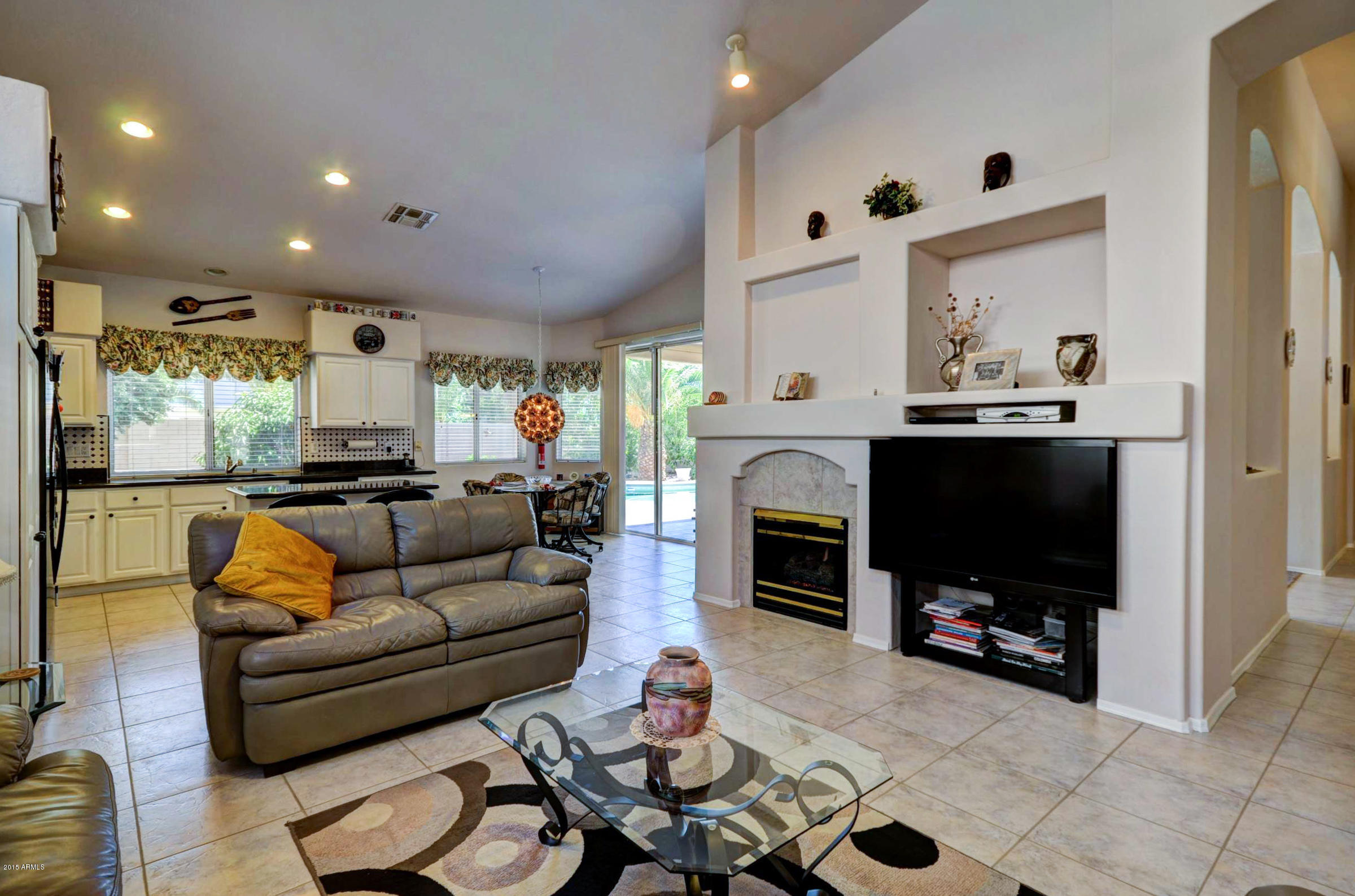 5311 East Danbury Road Scottsdale, AZ 85254 - Photo 11 of 39 a living room with furniture a flat screen tv and a fireplace