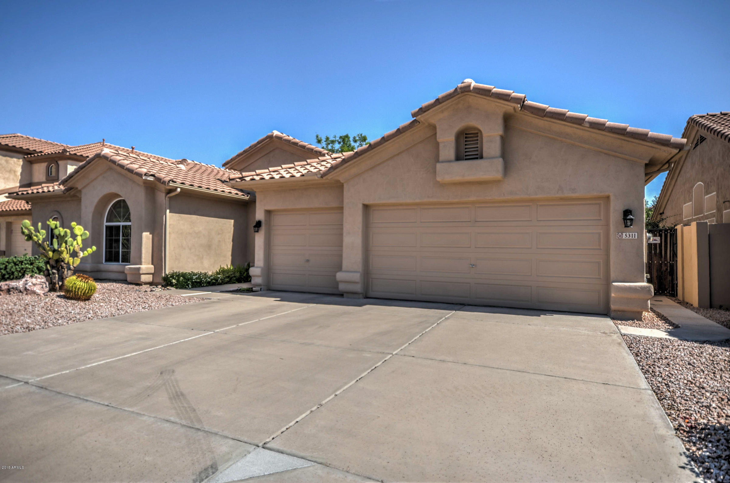 5311 East Danbury Road Scottsdale, AZ 85254 - Photo 2 of 39 a front view of a house with a yard and garage