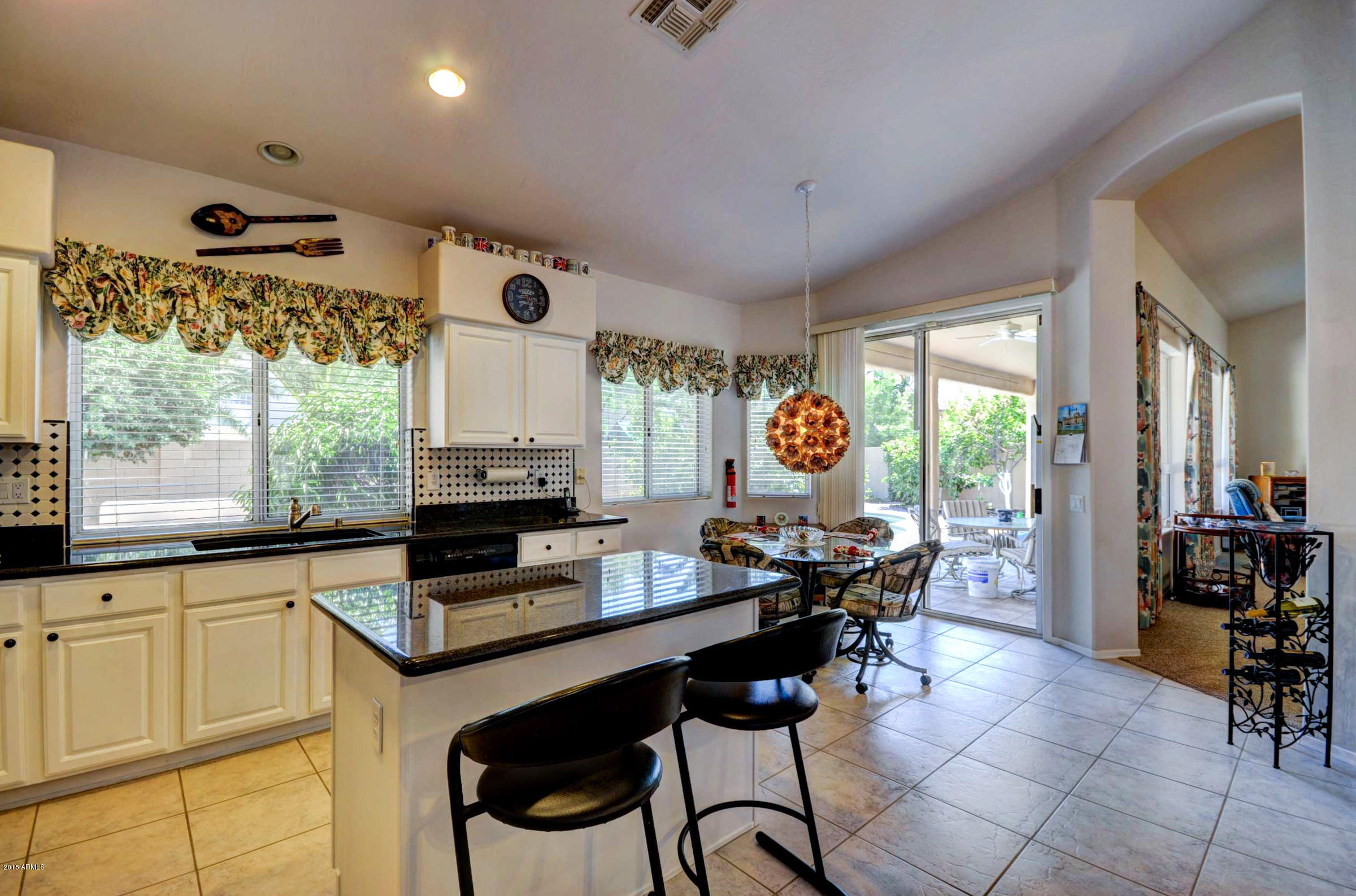 5311 East Danbury Road Scottsdale, AZ 85254 - Photo 8 of 39 a kitchen with stainless steel appliances granite countertop a stove a refrigerator a sink and chairs