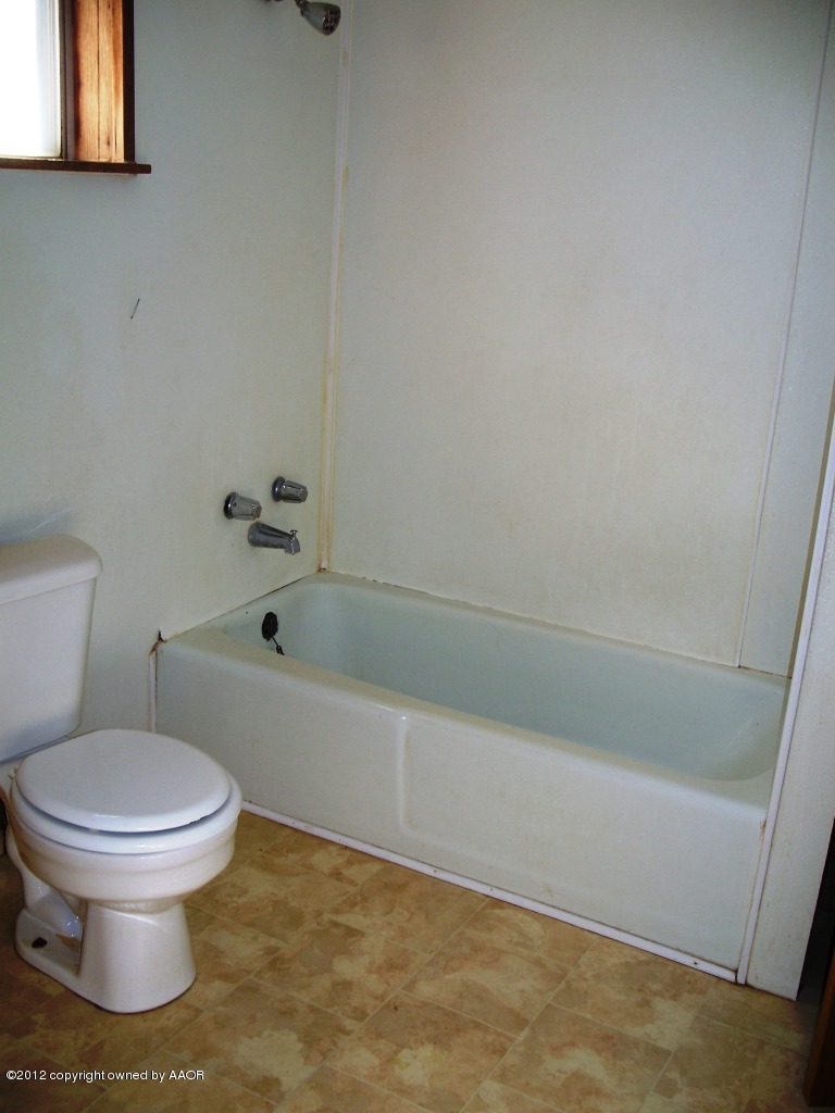 1115 West McCormick Road Amarillo, TX 79118 - Photo 8 of 15 a bathroom with a toilet and a bathtub