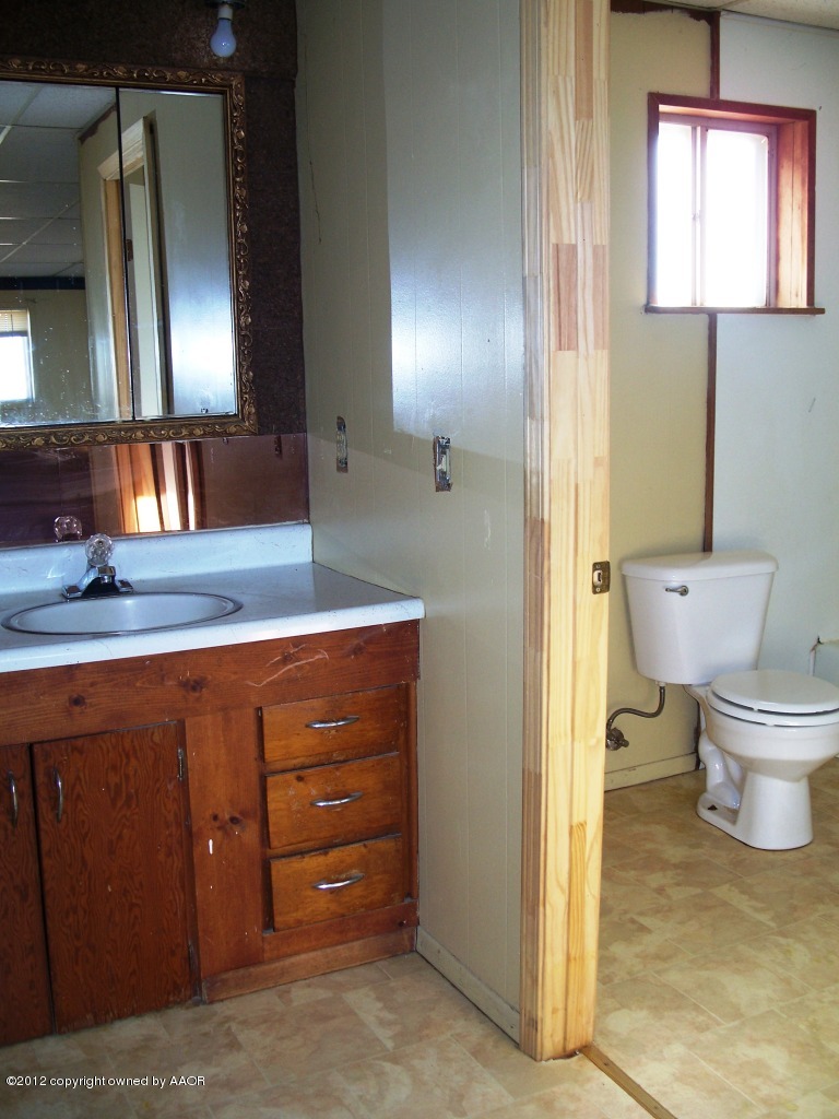1115 West McCormick Road Amarillo, TX 79118 - Photo 9 of 15 a bathroom with a toilet sink and mirror