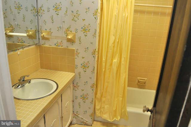 3909 Keswick Road Baltimore, MD 21211 - Photo 18 of 23 a bathroom with a sink a mirror and a shower