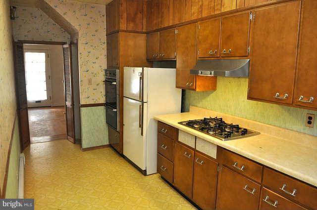 3909 Keswick Road Baltimore, MD 21211 - Photo 9 of 23 a kitchen with a refrigerator a stove top oven and cabinets