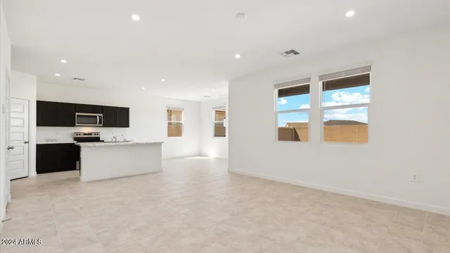 a view of kitchen with stainless steel appliances kitchen island in the middle