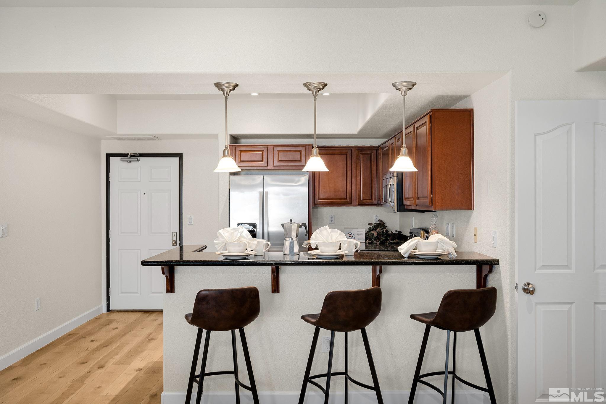 200 West 2nd Street, Unit 1503 Reno, NV 89501 - Photo 5 of 28 a kitchen with a counter and chairs in it