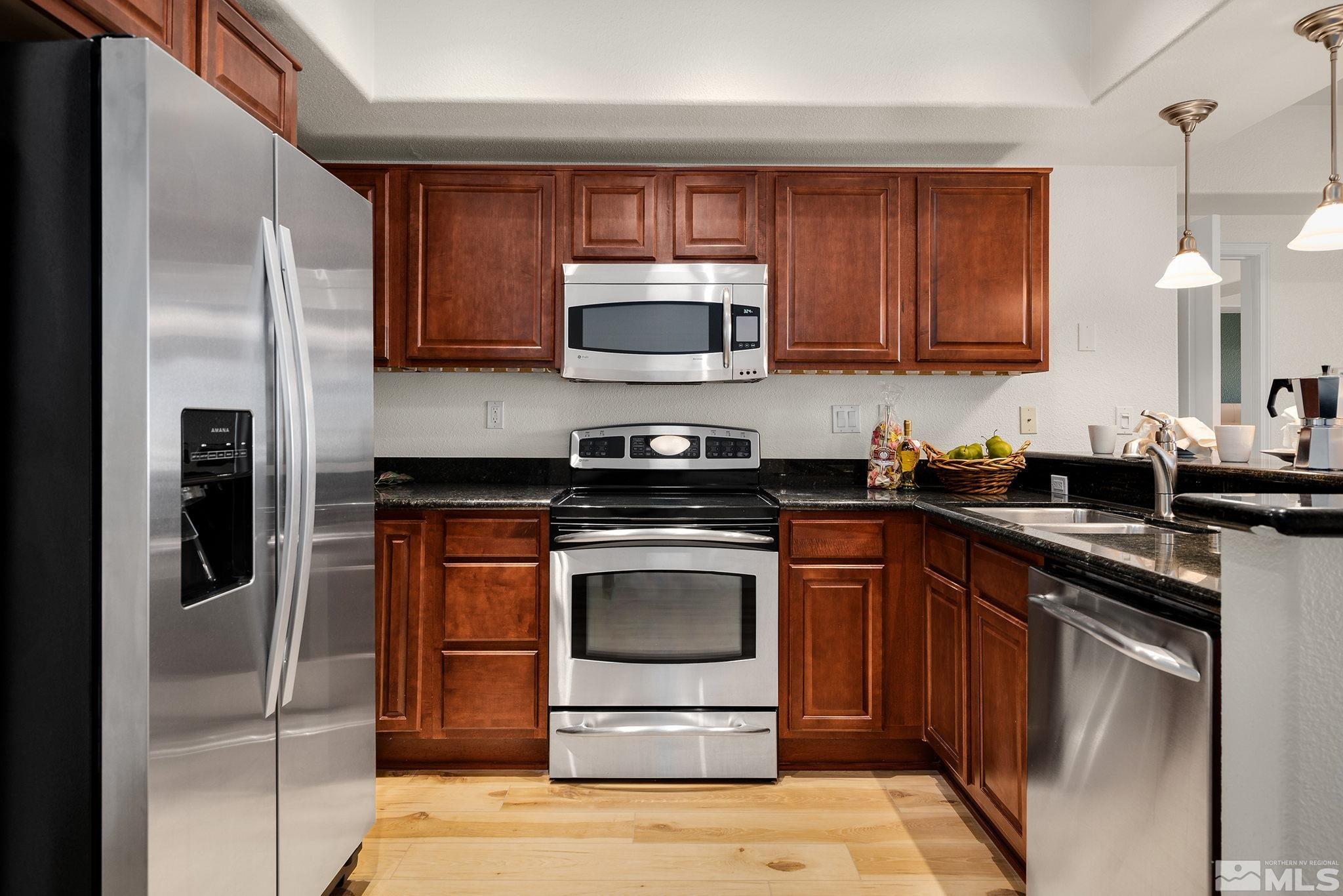 200 West 2nd Street, Unit 1503 Reno, NV 89501 - Photo 8 of 28 a kitchen with stainless steel appliances granite countertop a stove a refrigerator and a sink