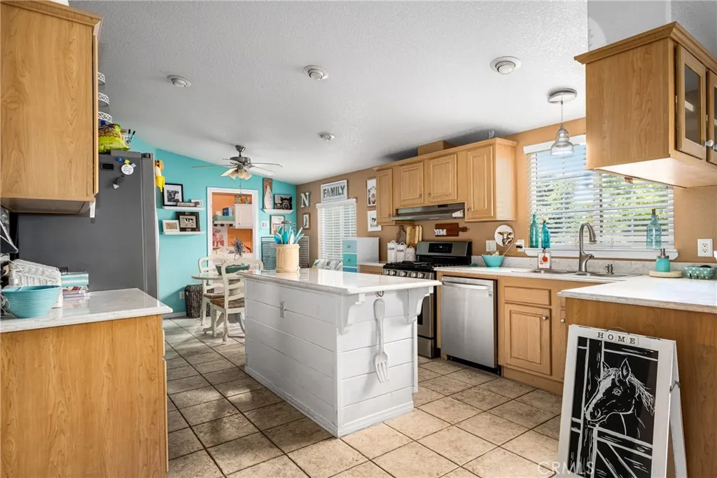 1051 Site, Unit 91 Brea, CA 92821 - Photo 19 of 32 a kitchen with stainless steel appliances granite countertop a stove top oven a sink a dining table and chairs