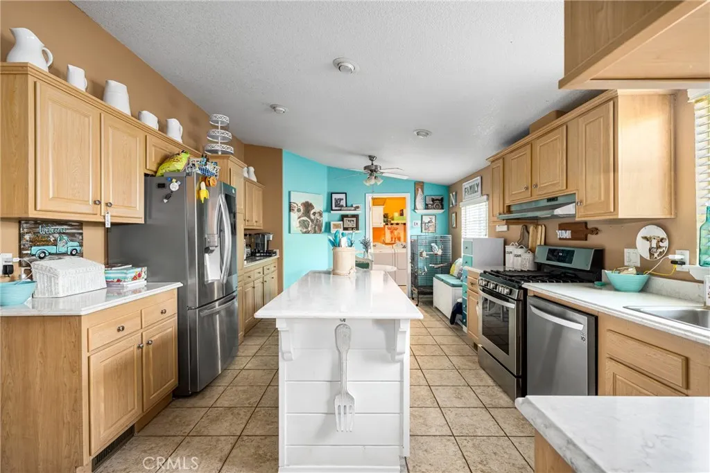 1051 Site, Unit 91 Brea, CA 92821 - Photo 21 of 32 a large kitchen with stainless steel appliances kitchen island granite countertop a sink counter space cabinets and a large window