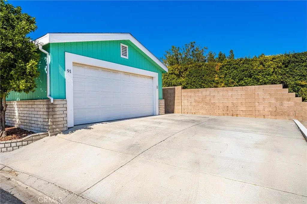 1051 Site, Unit 91 Brea, CA 92821 - Photo 5 of 32 a front view of a house with a yard and garage