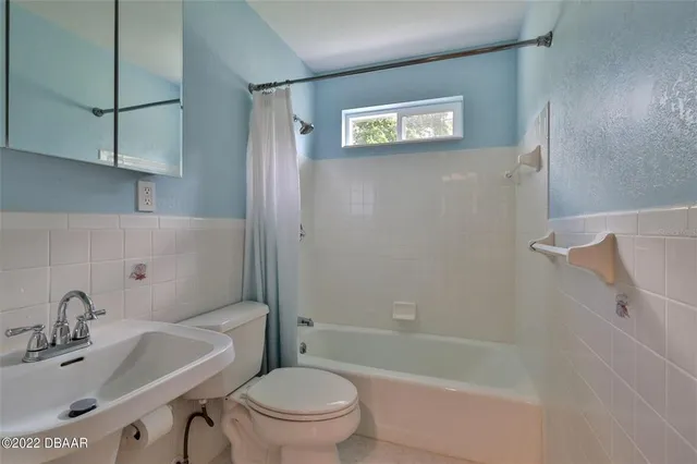 a bathroom with a bathtub shower sink vanity and toilet