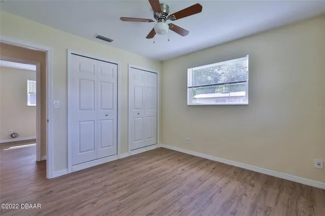 a view of an empty room with wooden floor
