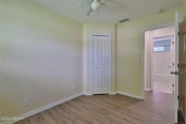 an empty room with wooden floor and closet