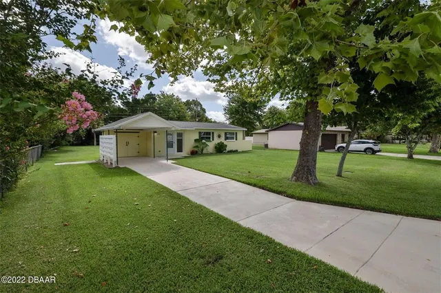 a front view of a house with yard and green space