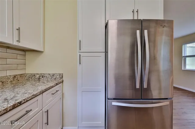 a metallic refrigerator freezer sitting in a kitchen