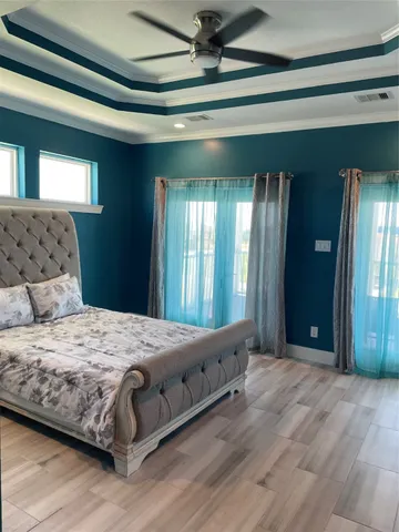 a bedroom with a large bed and a chandelier