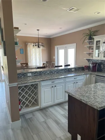 a kitchen with granite countertop a sink stove and cabinets
