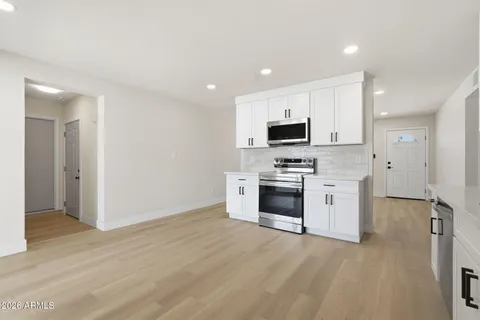 a kitchen with granite countertop a refrigerator and a stove top oven