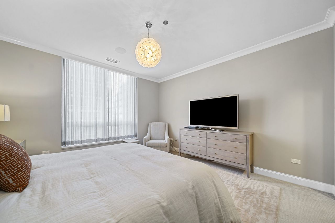 10 East Delaware Place, Unit 18E Chicago, IL 60611 - Photo 21 of 56 a bedroom with a bed and a flat screen tv